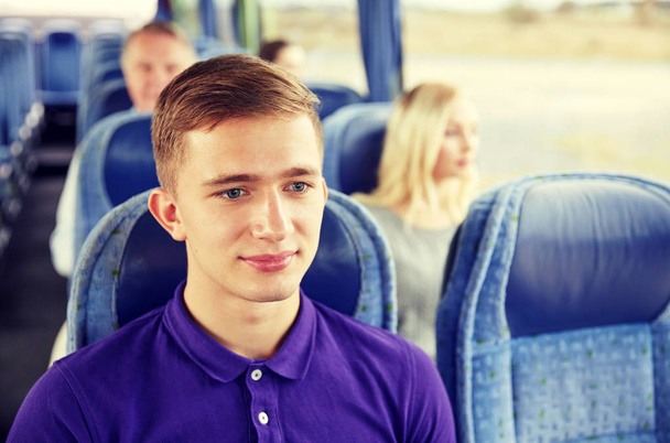 happy young man sitting in travel bus or train - Foto, afbeelding