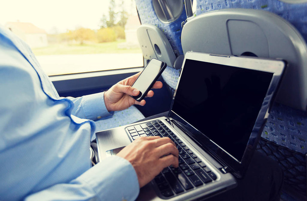 man with smartphone and laptop in travel bus - Foto, Imagem