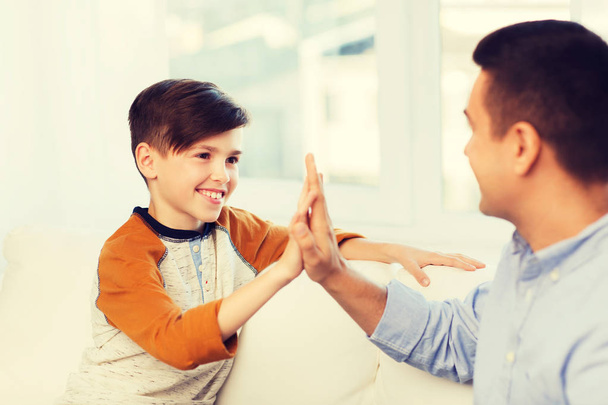 happy father and son doing high five at home - Foto, Imagen