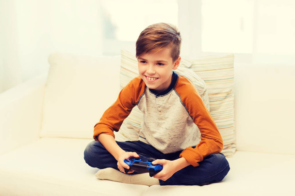 happy boy with joystick playing video game at home - Zdjęcie, obraz