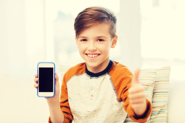 smiling boy with smartphone at home - 写真・画像