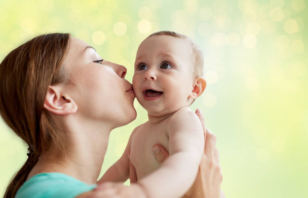 幸せな若い母親は赤ちゃんにキス - 写真・画像