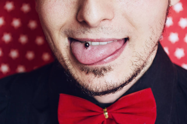 Hipster giovane uomo bastone fuori la sua linguetta con un piercing in esso  - Foto, immagini