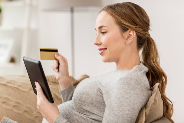 zwangere vrouw met tablet pc en creditcard - Foto, afbeelding