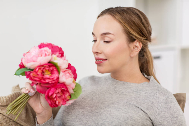 happy woman smelling flowers at home - Photo, Image