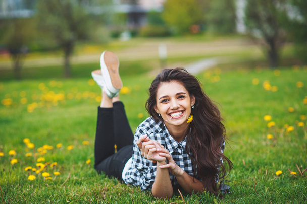Beautiful brunette woman holding a flower in the teeth  and smiling - Φωτογραφία, εικόνα