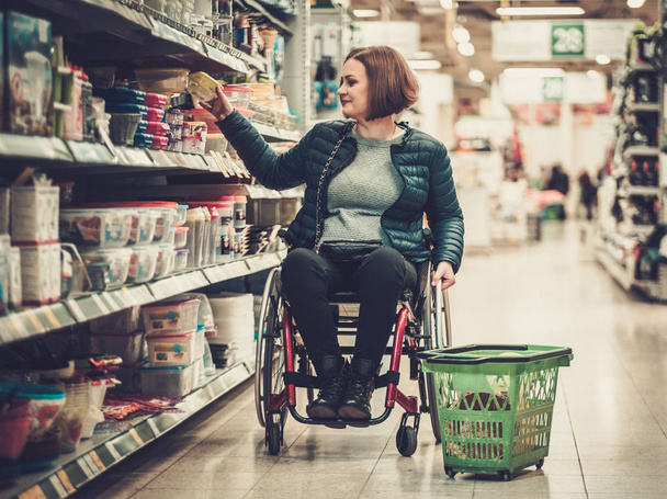 γυναίκα σε μια αναπηρική καρέκλα σε ένα πολυκατάστημα - Φωτογραφία, εικόνα