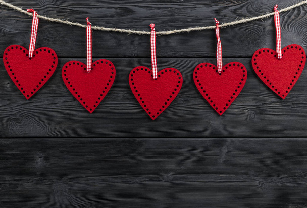 red hearts on the black rustic wooden background with woodgrain texture - Fotoğraf, Görsel