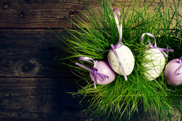 Uova di Pasqua su erba verde fresca su sfondo di legno
.  - Foto, immagini