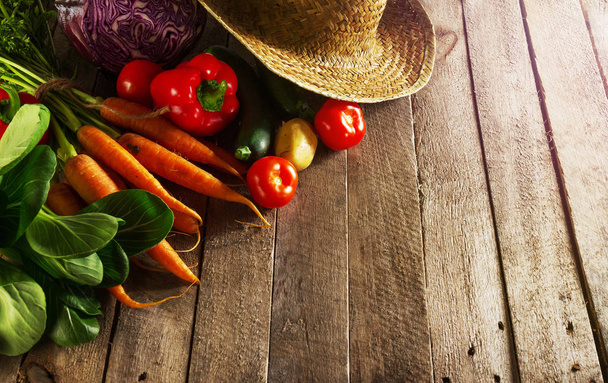 Beautiful fresh harvest vegetables on wooden table with straw hat - Fotografie, Obrázek