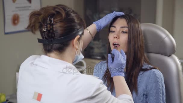 Médico examina uma paciente feminina na clínica
 - Filmagem, Vídeo