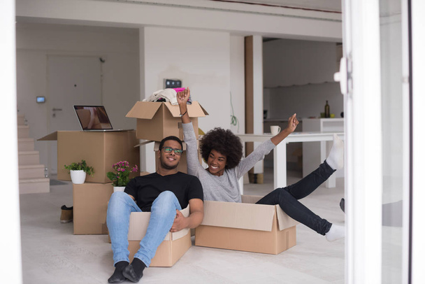 Afrikaanse Amerikaanse echtpaar spelen met verpakkingsmateriaal - Foto, afbeelding