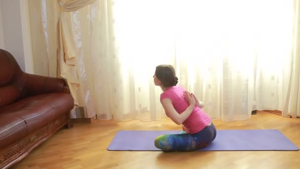 Giovane donna che fa esercizi di stretching a casa - Filmati, video