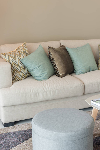 moderne woonkamer met groene kussens op de gezellige sofa en houten la - Foto, afbeelding