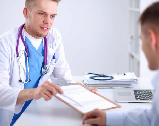 Doctor male giving patient folder with  paper in her office, isolated - Foto, imagen