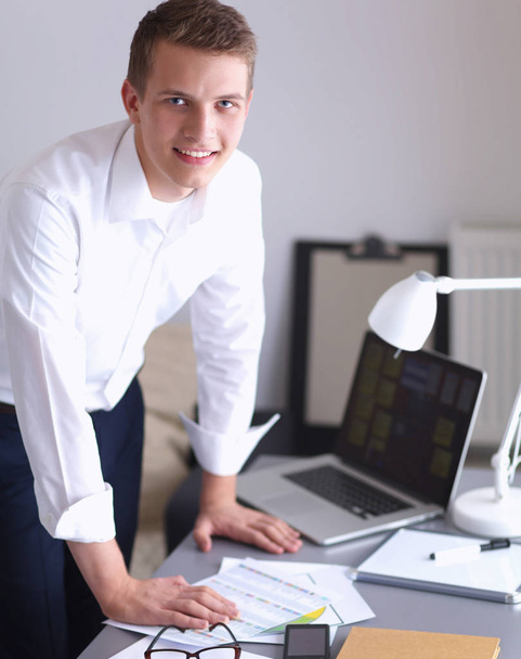 Young businessman working in office, standing near desk - Foto, Imagem