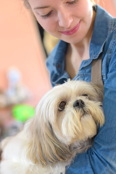 portrait of young woman and her dog in pet store - Photo, image