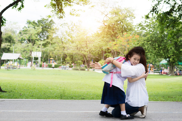 Дети учатся в руках матери, чтобы обнять ее после школы
 - Фото, изображение