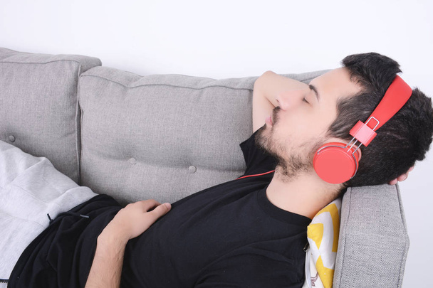 Man listening music on couch. - Foto, afbeelding