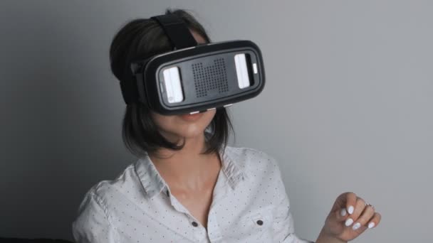 Vrouw maakt gebruik van een hoofd gemonteerde display. Een vrouw in een virtuele realiteit masker kijkt rond. - Video