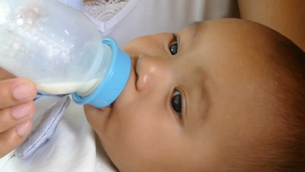 Asian mother feeds her baby with bottle  - Imágenes, Vídeo