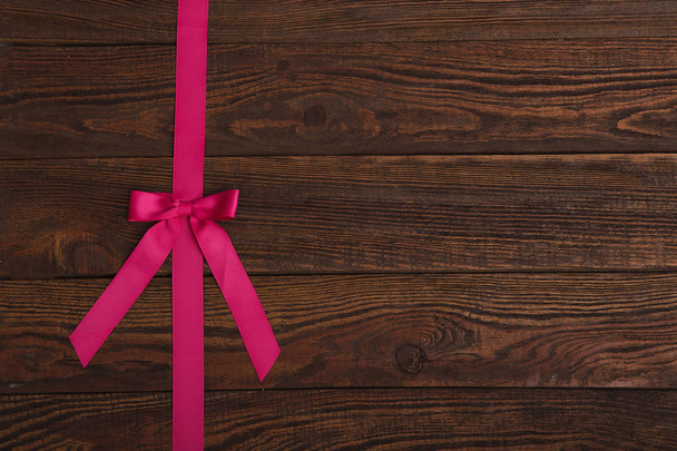 plank houtstructuur achtergrond met roze lint - Foto, afbeelding
