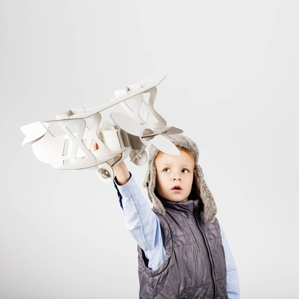 Child boy playing with paper toy airplane and dreaming of becomi - Photo, Image