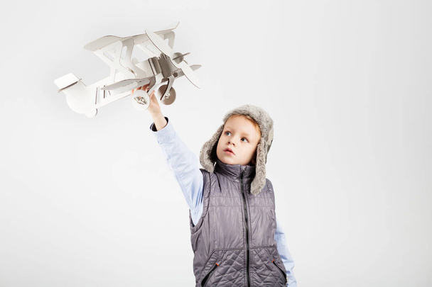 Αγόρι παιδί παίζοντας με toy αεροπλάνο χαρτί και ονειρεύεται becomi - Φωτογραφία, εικόνα