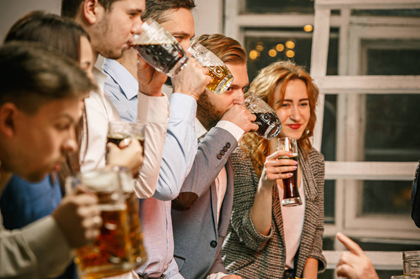 Group of friends enjoying evening drinks with beer - Fotografie, Obrázek