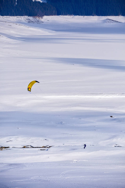 pessoas fazendo kitesurf em um lago de montanha congelado
 - Foto, Imagem