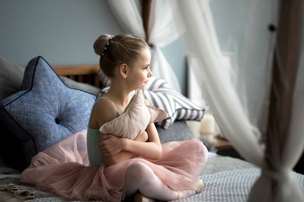 балерина сидит на кровати
 - Фото, изображение