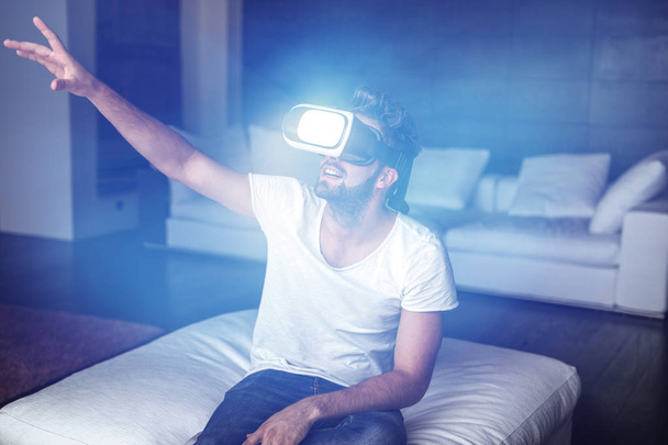 Jonge man genieten van virtuele realiteit door headset met kunstmatige li - Foto, afbeelding