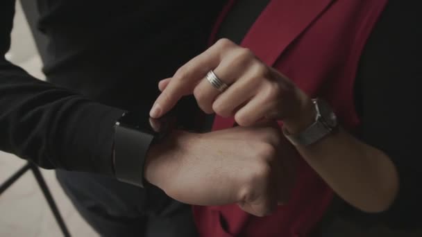 Primer plano del hombre mostrando a su novia los beneficios de smartwatches en el brazo
. - Imágenes, Vídeo