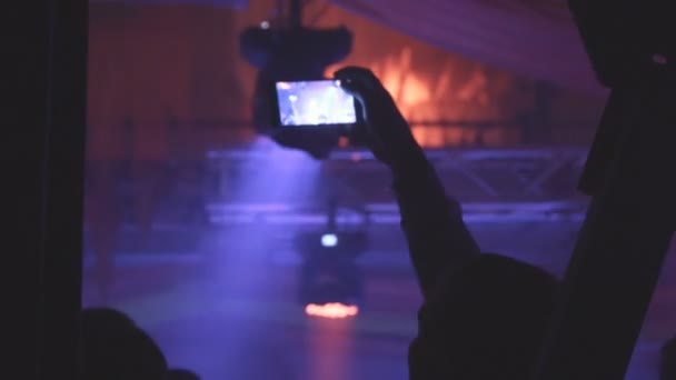Gente tomando fotos o grabando videos con sus teléfonos inteligentes en un concierto de música
 - Metraje, vídeo