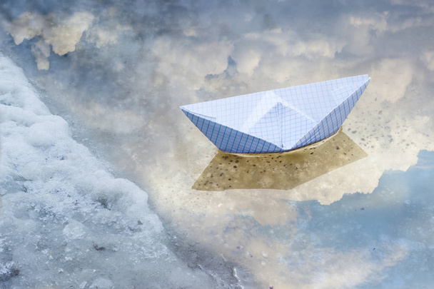 Паперовий човен у калюжі з води з танення снігу
 - Фото, зображення