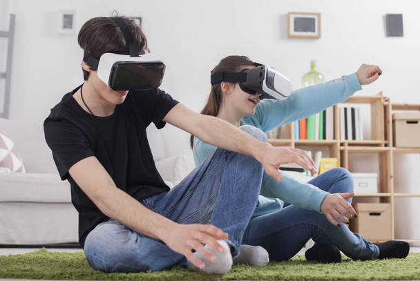Teenagers with VR glasses in living room - 写真・画像