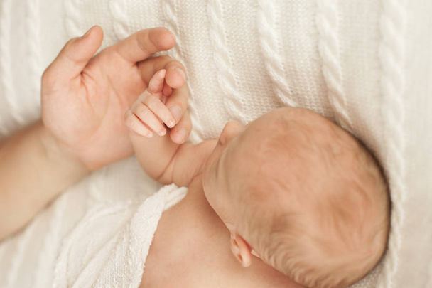 mano del padre sosteniendo al recién nacido
 - Foto, imagen