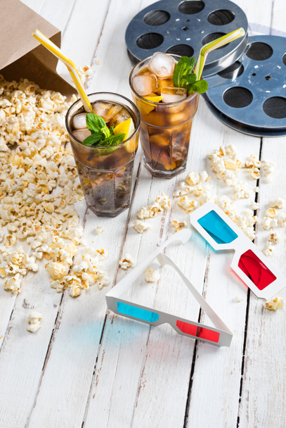 Popcorn with iced tea and film reels    - Photo, Image