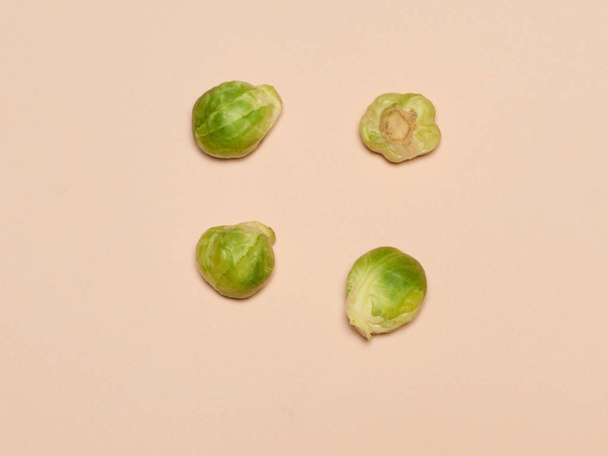 The many piles of Brussels sprouts on a pink background - Foto, afbeelding