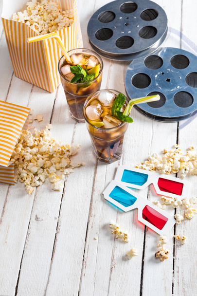 Popcorn with iced tea and film reels    - Foto, afbeelding