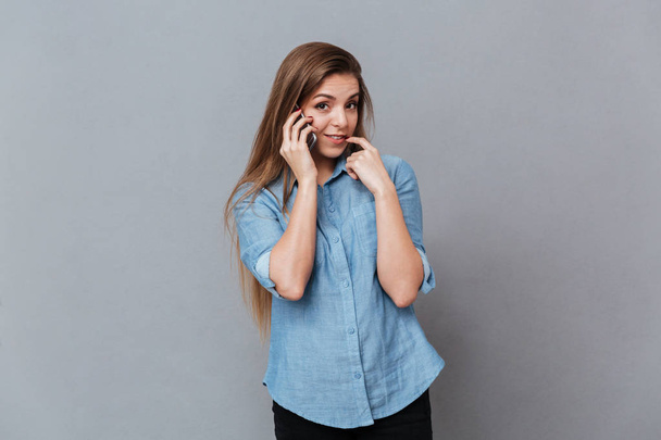 Shy Woman in shirt talking on phone - Фото, зображення