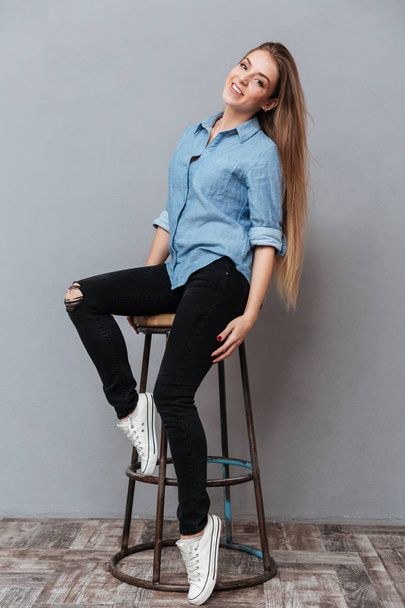 Vertical portrait of Woman in shirt sitting on chair - Photo, image