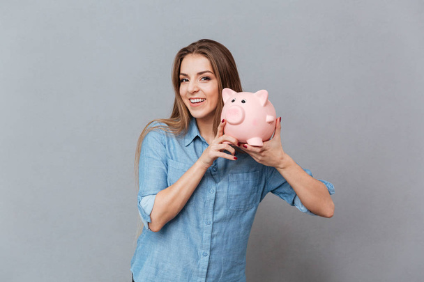 Woman in shirt holding moneybox in hands - Foto, Imagen