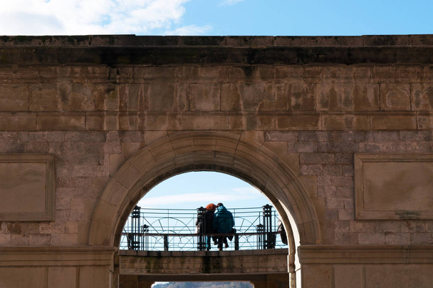 Donostia-San Sebastian: a couple seated on a bench in the Parte Vieja, the Old Town and the original nucleus of the city - Fotoğraf, Görsel