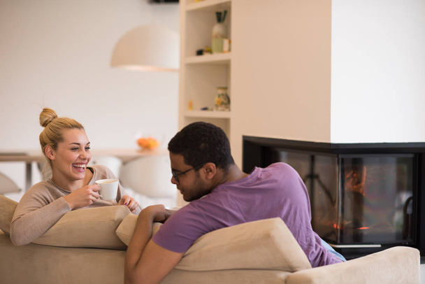 Young multiethnic couple  in front of fireplace - Φωτογραφία, εικόνα