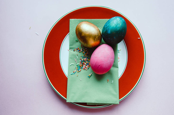 colorful easter eggs with confectionery sprinkling on plate - Valokuva, kuva