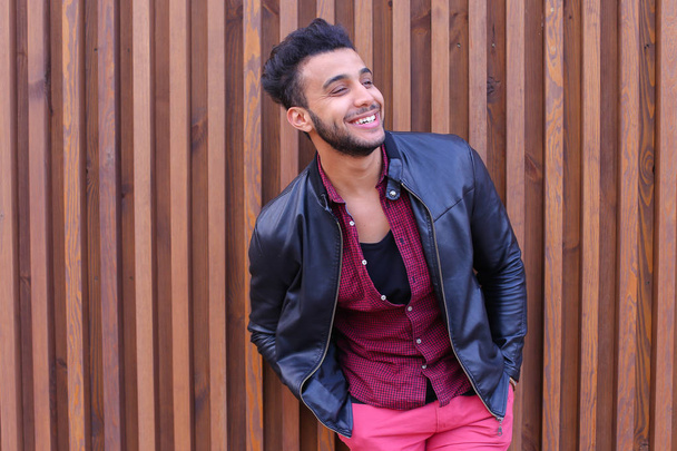 schön aussehender arabischer junger mann steht in der nähe der wand und lächelt, lacht - Foto, Bild