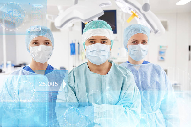 group of surgeons in operating room at hospital - Photo, image