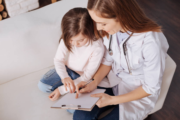 Professional doctor giving little girl a piece of advice - Фото, зображення