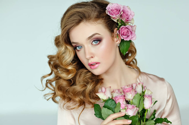 Portrait of a beautiful blonde girl with delicate pink roses on  - Foto, immagini